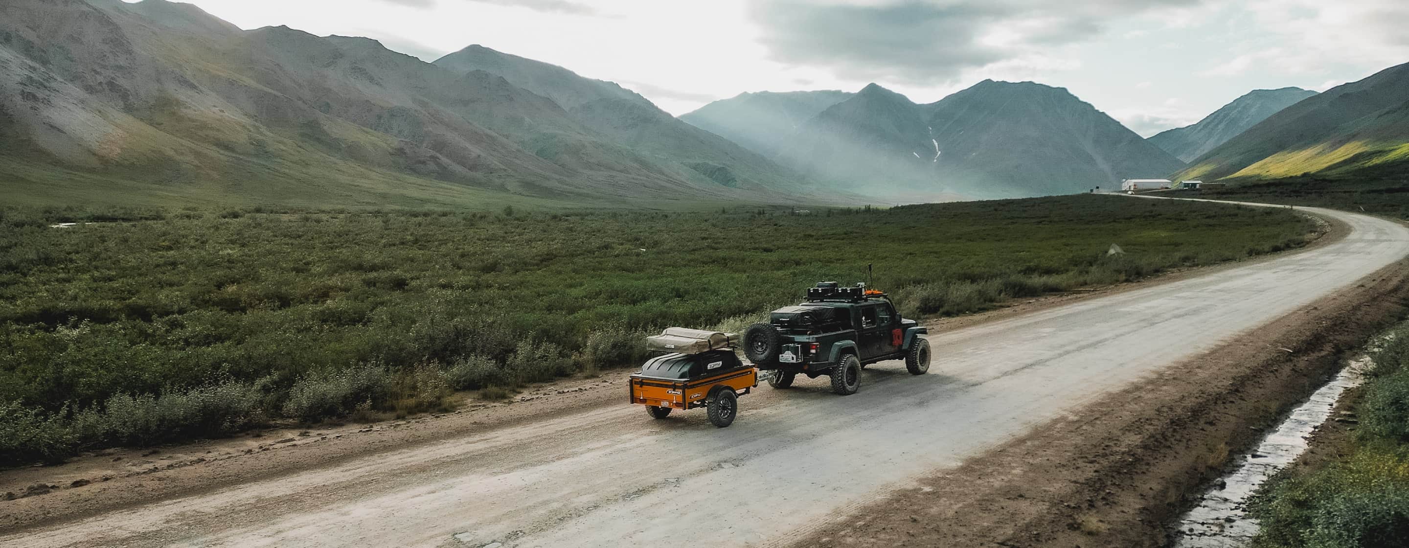 Overland vehicle driving through valley